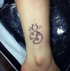 a small cat tattoo on the ankle is shown in black and grey ink, with an outline of a cat holding a kitten's tail