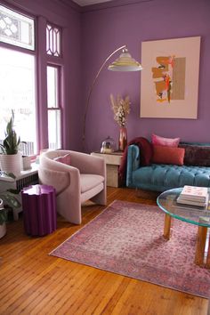 a living room with purple walls and wooden floors