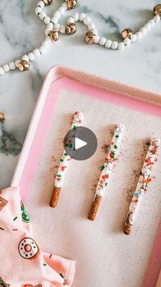 three decorated candy sticks on a tray