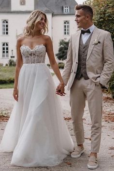 a man and woman are holding hands in front of a house