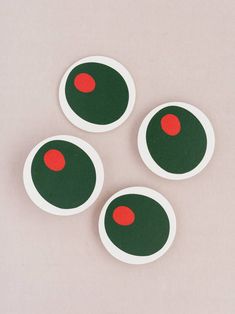 four green and red circles on a white surface