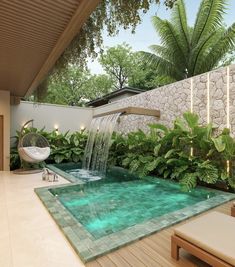 an outdoor swimming pool surrounded by greenery and lights with a waterfall running down the side