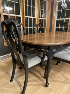 a dining room table and chairs in front of windows