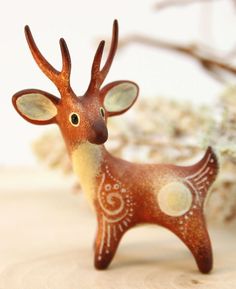 a small deer figurine sitting on top of a wooden table next to some branches