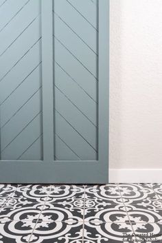 a black and white tile floor next to a blue door