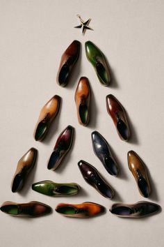 a christmas tree made out of shoes on a white surface with a star in the middle