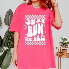 Calling all runners, chill walkers, and weekend warriors!  This comfy tee is your perfect summer companion, featuring a retro font that says "Just Run The Miles" on a rad checkered print.  Available in these chill summer colors: 🌸Crunchberry Island Reef 🧦Pepper 🪁Orchid  This comfy tee is made with 100% ring-spun cotton for a super soft feel. It's perfect for your next run, walk, or just hanging out in style.  Rep your love for movement in a way that's both fun and functional.  Add this tee to Summer Workout T-shirt With Text Print, Summer Sports T-shirt With Screen Print, Sporty Graphic Print T-shirt For Marathon, Graphic Tee T-shirt For Spring Workout, Summer Letter Print T-shirt For Workout, Spring Workout T-shirt With Graphic Print, Pink Letter Print Athleisure T-shirt, Summer Workout T-shirt With Graphic Print, Retro Sports T-shirt For Summer