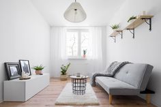 a living room with white walls and wooden floors