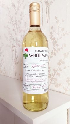 a bottle of white wine sitting on top of a table next to a wallpaper