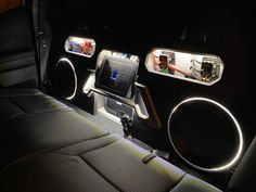 the interior of a car is lit up with lights and speakers on it's dash board