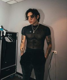 a man with tattoos standing in a room