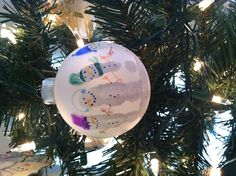 an ornament hanging from a christmas tree with snowmen painted on the ornaments