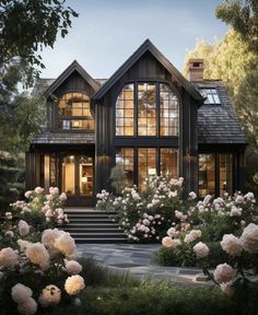 a house with lots of windows and flowers in the front yard