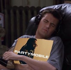 a man laying in a chair holding a sign with the words partymobile on it