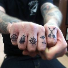 two fingers with small tattoos on them, one has an anchor and the other has a ship