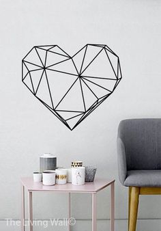 a heart shaped wall sticker on the wall next to a small table and chair