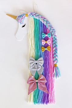 a unicorn head with colorful hair and bow ties on it's side, next to a rainbow mane