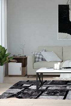 a living room filled with furniture and a painting on the wall above it's coffee table