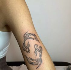 a woman's arm with a fish tattoo on it