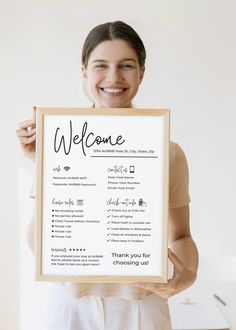 a woman holding up a sign with the words welcome in black and white on it