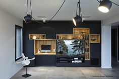 a black and white room with lots of shelves on the wall, lights hanging from the ceiling