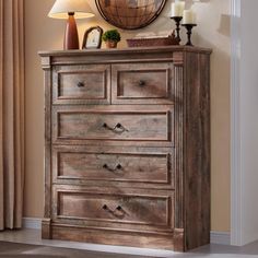 a wooden dresser sitting next to a wall with a clock on it's side