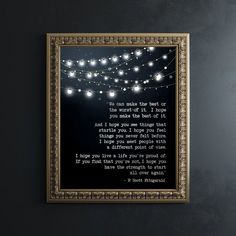 a framed poem with string lights hanging on the wall in front of a black background