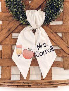 two personalized teacher's day tea towels hanging on a wooden door hanger