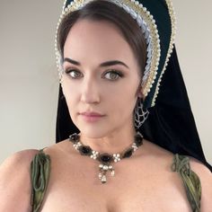 Handcrafted replica period jewelry, made to imitate the style and grandeur of the Tudors. This elegant necklace will complement any renaissance garb, and elevate even the most simple gown into a piece fit for a queen. It is made to order in your choice of gold, silver, or bronze and can be set with resin gemstones of just about any color. Ruby, emerald, sapphire, amethyst and onyx are most popular options.The Elizabeth is made with a row of stunning lace bordered cabochon bases, connected by clustered pearls. 3 Teardrop pearls dangle beautifully from the center cabochon. Tudor Gown, Simple Gown, Period Jewelry, The Tudors, Simple Gowns, Tudor Style, Ruby Emerald, Elegant Necklace, Lace Border