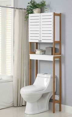 a white toilet sitting next to a wooden shelf with drawers on it's sides