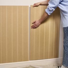 a person standing next to a wall with wooden paneling on it's sides