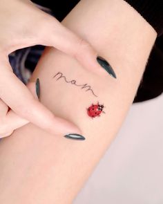 a ladybug tattoo on the left side of her right arm, with words written in cursive writing