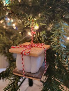 an ornament hanging from a christmas tree decorated with marshmallows and candy canes