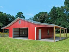 a red barn with two garages in the grass