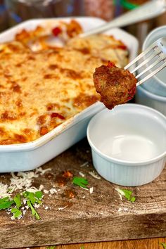 a piece of meatball and cheese casserole being lifted from a dish with a fork