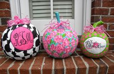 three decorative pumpkins with monogrammed designs are sitting on the front steps outside