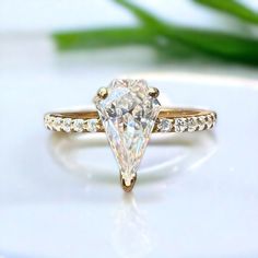 an engagement ring with a pear shaped diamond