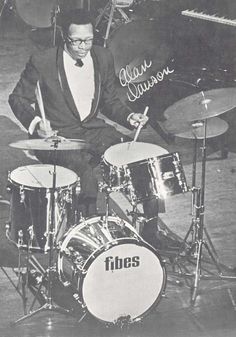 a man in a tuxedo is playing drums