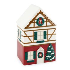 a ceramic house with a christmas wreath on the front and side of it, sitting in front of a white background