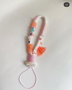 an orange, white and blue beaded bracelet with tassels on the end