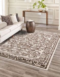 a living room with a white couch and brown rug