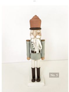 a wooden nutcracker figure with a hat and scarf on it's head