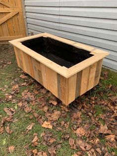 a wooden planter box sitting in the grass