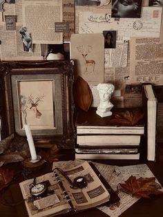 there are many books and pictures on the table with an old clock in front of them