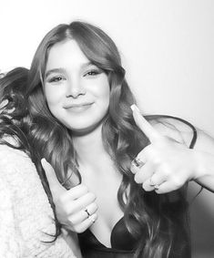 two women giving the thumbs up sign in black and white