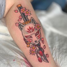 a cat tattoo on the leg of a woman with flowers around her neck and head