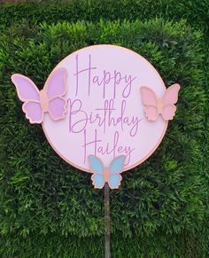 a sign that says happy birthday harley with two butterflies on it and grass in the background