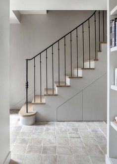 a white staircase with metal handrails and bookshelves