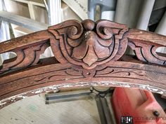 an old wooden bench with carvings on the back and sides, sitting in a shop