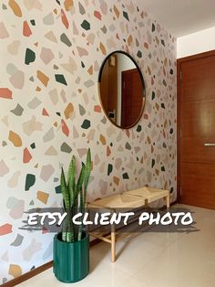 a room with a mirror, potted plant and wall paper on the walls that says easy client photo